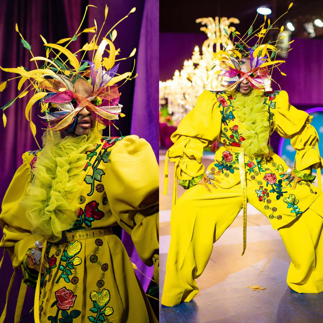 Denrele Edun wearing a yellow floral-embroidered suit, ruffled lime green collar, and a feather mask headpiece.
