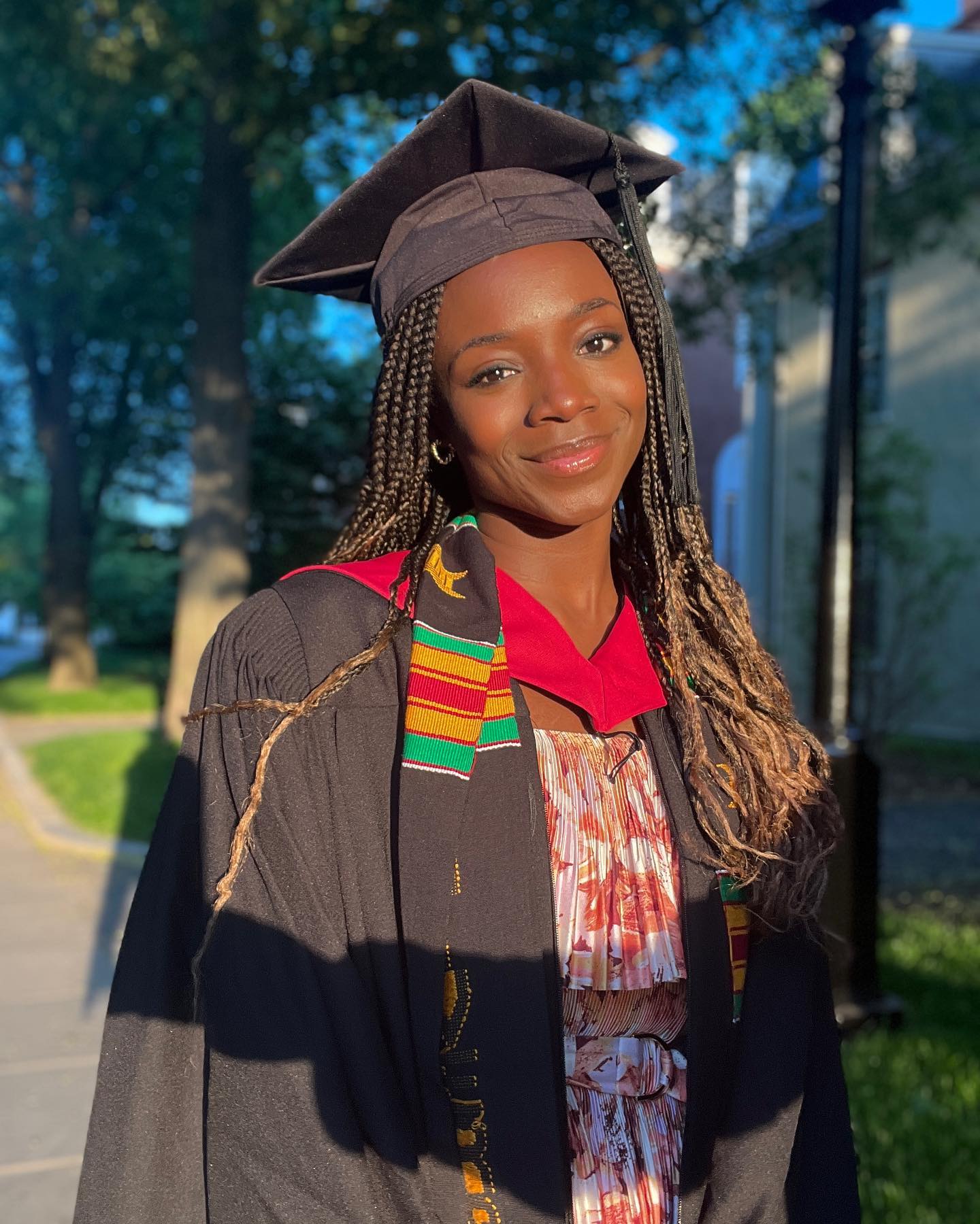 Nigerian-born engineer Yinka Ogunbiyi wearing a graduation gown, cap, and kente stole at Harvard.
