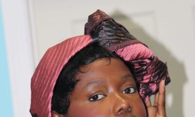 Solange Omon wearing a metallic pink headwrap and gold hoop earrings.