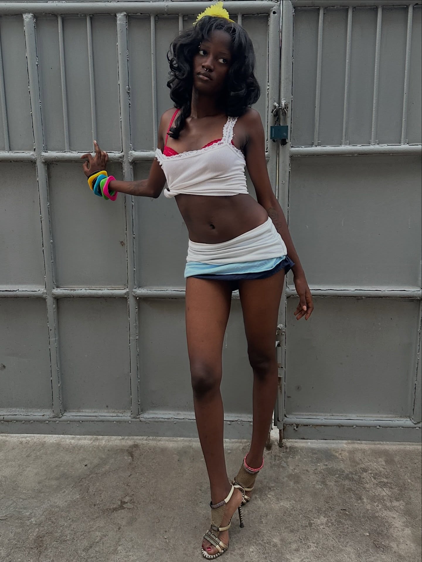 Rachael Ojuromi in a white top, mini skirt, and heels posing in Lagos.