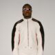 Asake wearing a white and black leather biker suit with oval sunglasses reflecting his Mr Money persona.