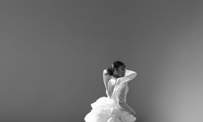 Mide Iwasokun in a black and white portrait displaying the long cascading train and high leg slit of her custom Komeh Swish gown.