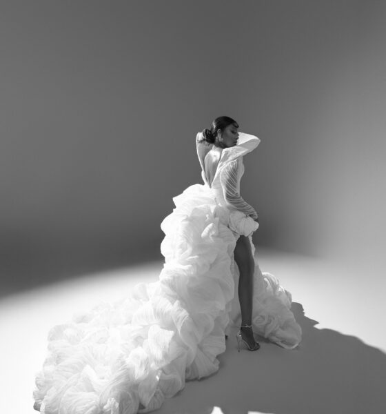 Mide Iwasokun in a black and white portrait displaying the long cascading train and high leg slit of her custom Komeh Swish gown.