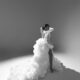 Mide Iwasokun in a black and white portrait displaying the long cascading train and high leg slit of her custom Komeh Swish gown.