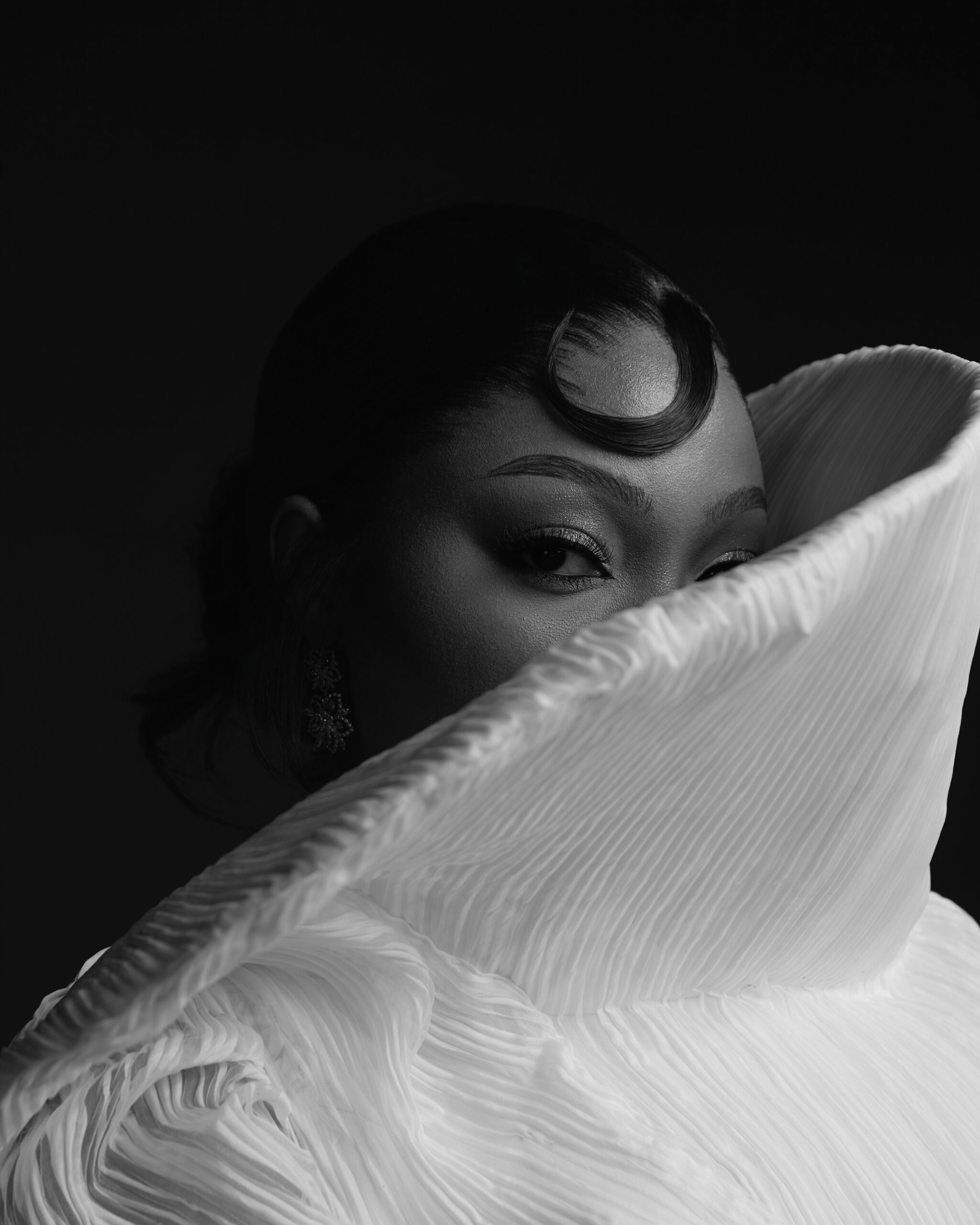 Mide Iwasokun’s face framed by the exaggerated white fan collar of her Komeh Swish dress.