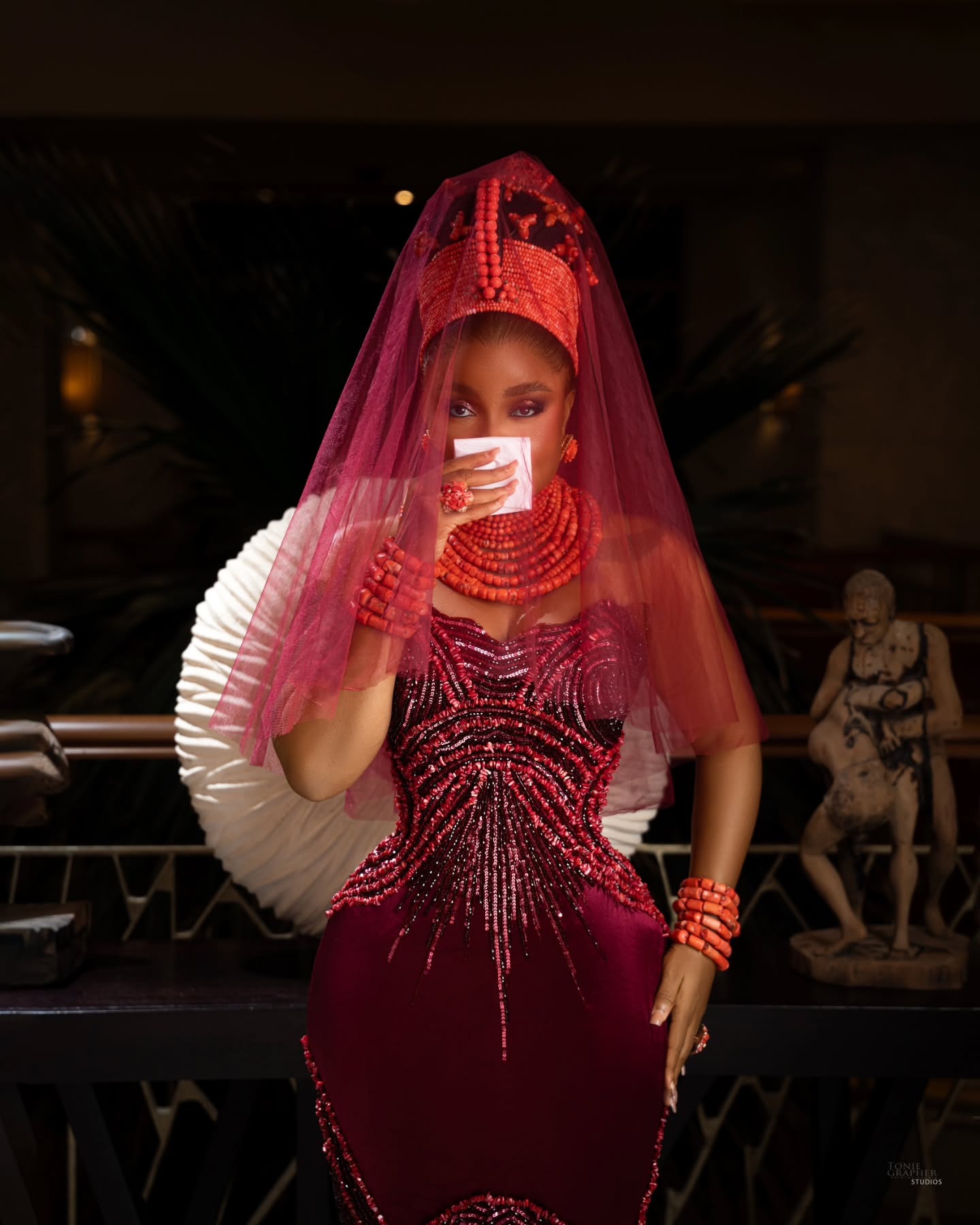 Bimbo Ademoye wearing a red veil Okuku coral crown and maroon velvet beaded gown for My 30th Wedding