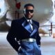 Ebuka Obi-Uchendu with hands in pockets wearing custom Mai Atafo wide-leg satin trousers and cutout dress shoes.
