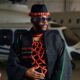 Ebuka Obi-Uchendu wearing a webbed coral bead torso piece under a black hand-woven Atafo coat for BBNaija Season 11 grand finale.
