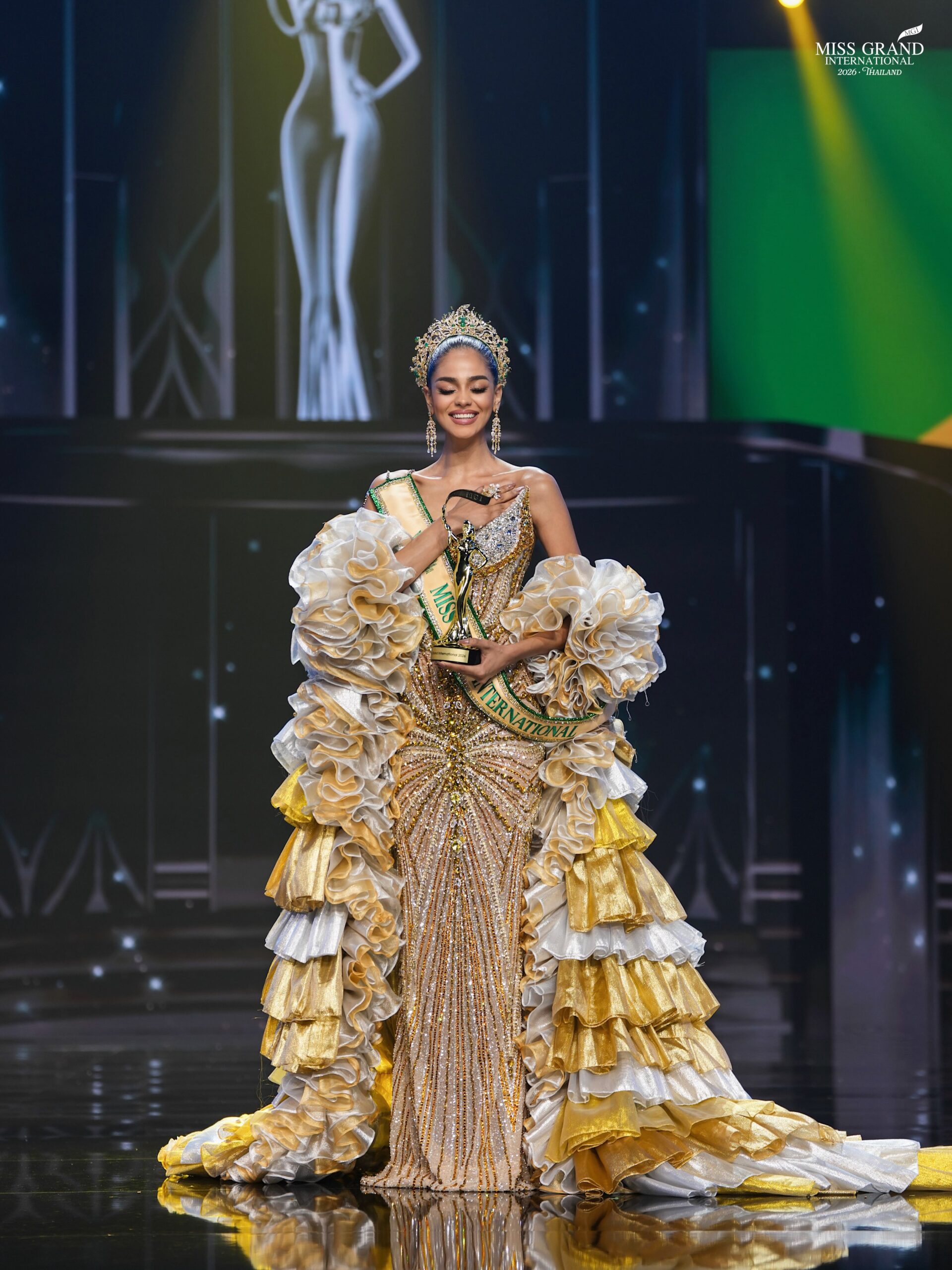 Jihan Mohin Dimack on stage holding her trophy and wearing her Miss Grand International 2026 crown and sash.