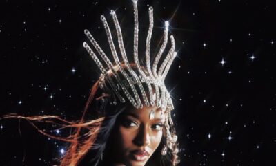 Nigerian singer Ayra Starr wearing a metallic purple dress and a jeweled crown headpiece against a starry night background for her Starrgirl album and tour promo.