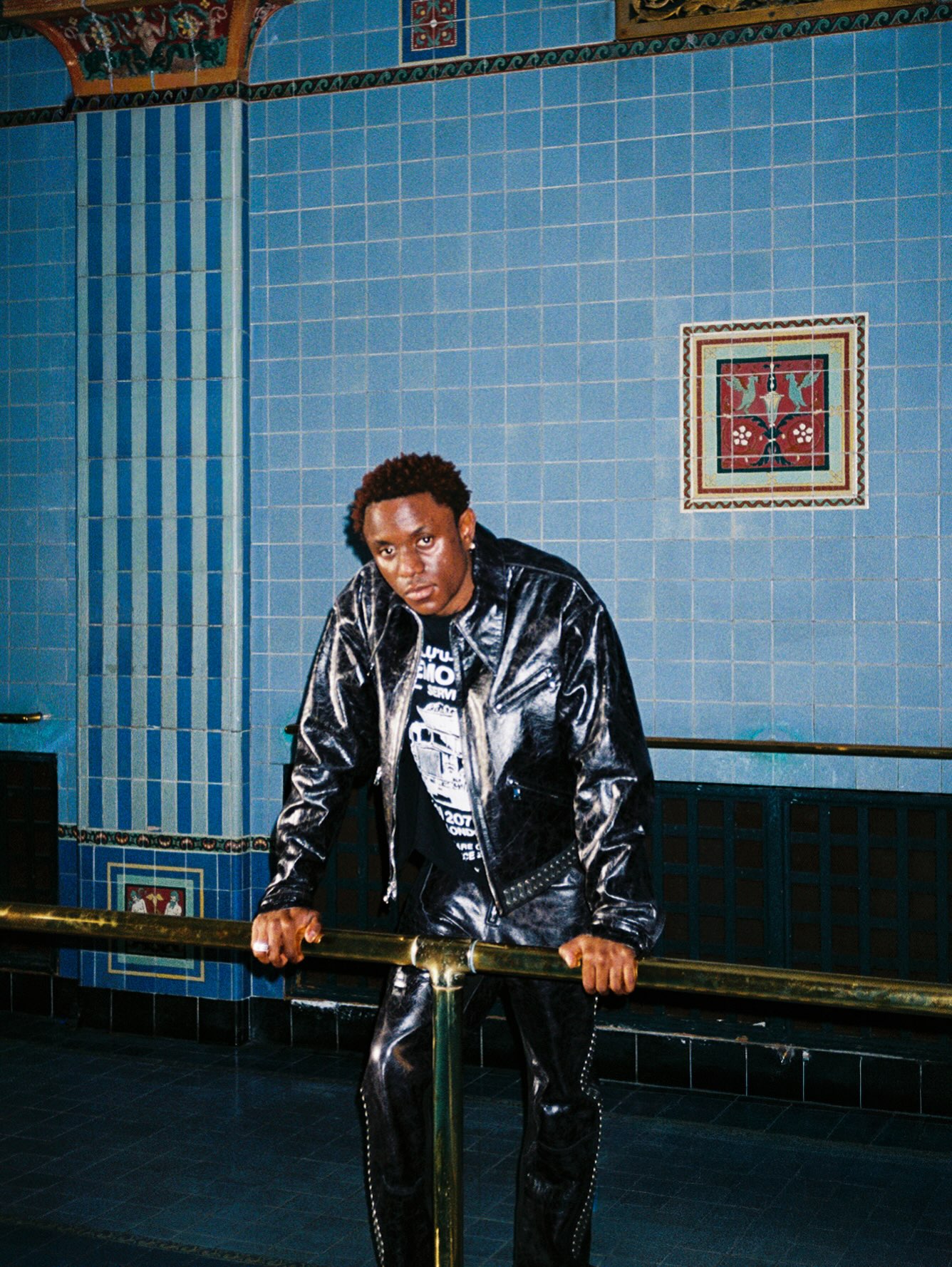 Nigerian singer-songwriter Victony wearing a glossy leather outfit on set during the production of the SLICK Remix, featuring American stars Don Toliver and Summer Walker, off his sophomore album STARLIFE.