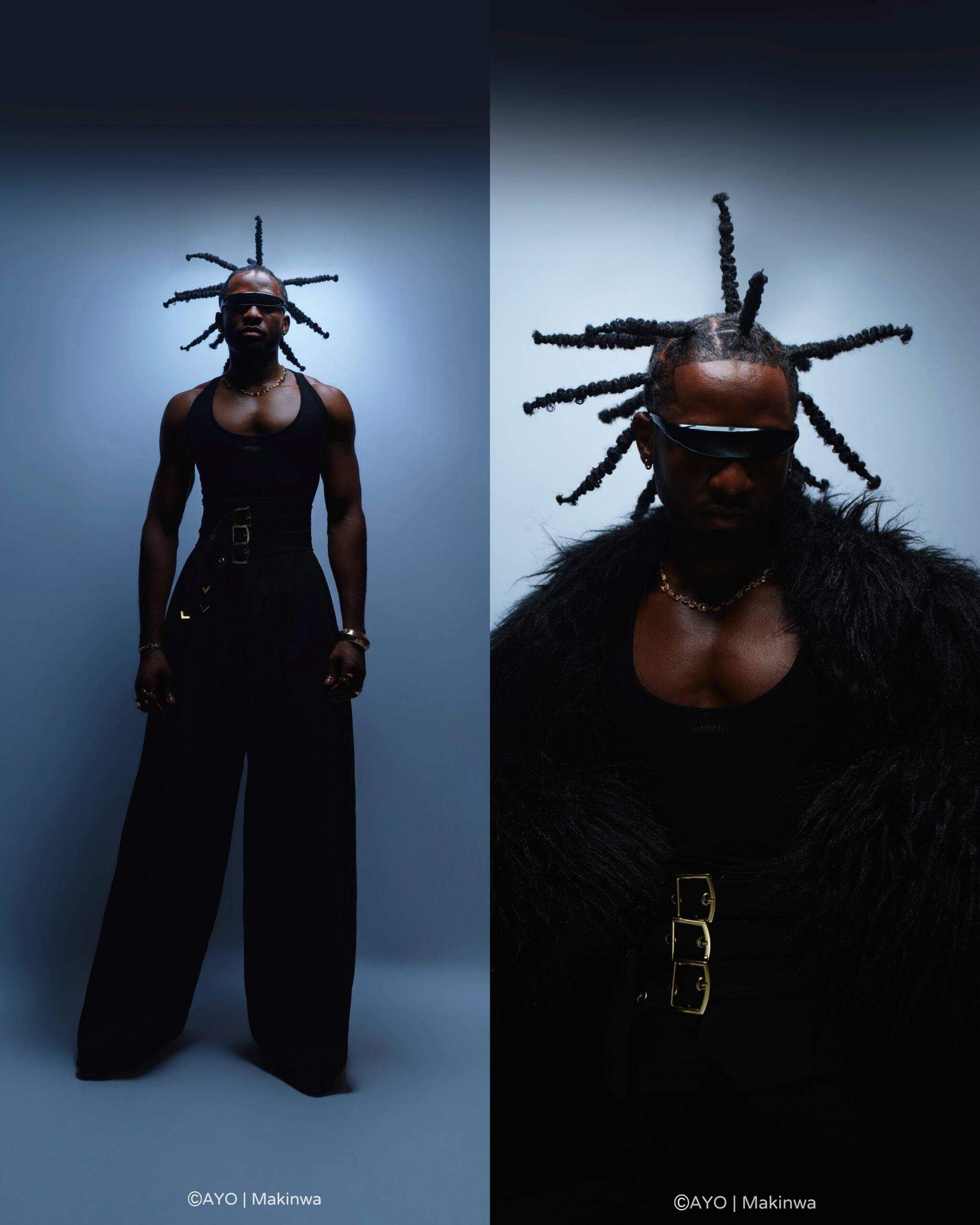 Chimezie Imo with spiked braided hair wearing a black tank top, black fur coat, triple-buckle belt, and futuristic visor sunglasses.