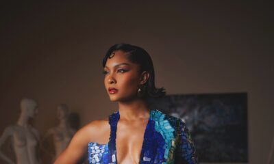 Osas Ighodaro wearing a deep plunge blue mother-of-pearl mosaic gown with one long sleeve.