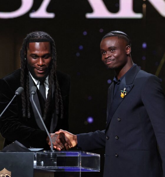 Burna Boy shaking hands with Bukayo Saka at the podium during the 2026 Ballon d’Or ceremony in London.