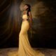 Ashiogwu Precious Dede in a low-rise butter yellow maxi skirt with a sweeping train and bandeau top.