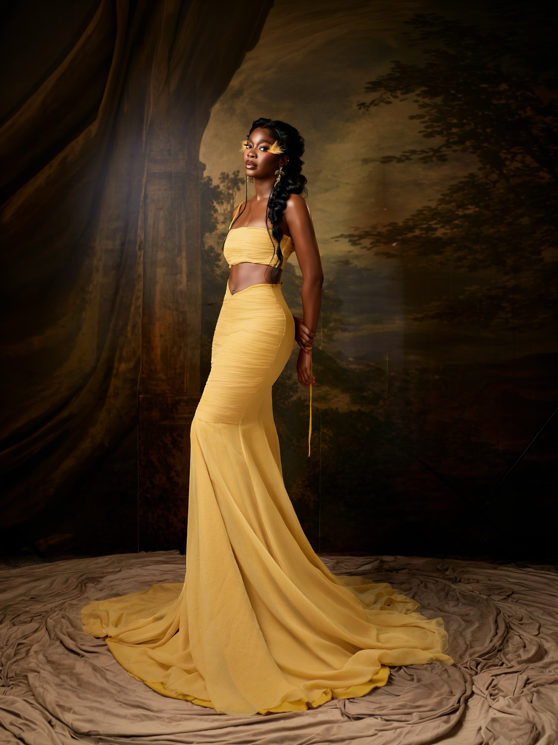 Ashiogwu Precious Dede in a low-rise butter yellow maxi skirt with a sweeping train and bandeau top.
