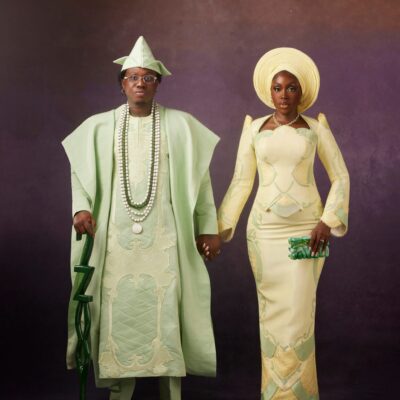 Zlatan Ibile in a mint green Mazelle Bridal Agbada holding hands with Davita Omoniyi in a pale lemon-yellow Mazelle Bridal structured top and skirt for their Yoruba traditional wedding.