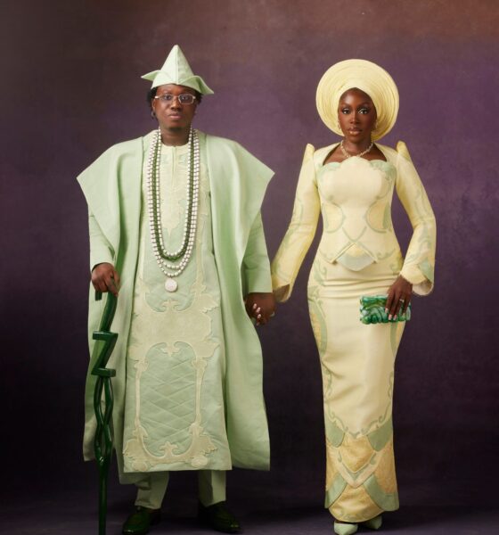 Zlatan Ibile in a mint green Mazelle Bridal Agbada holding hands with Davita Omoniyi in a pale lemon-yellow Mazelle Bridal structured top and skirt for their Yoruba traditional wedding.