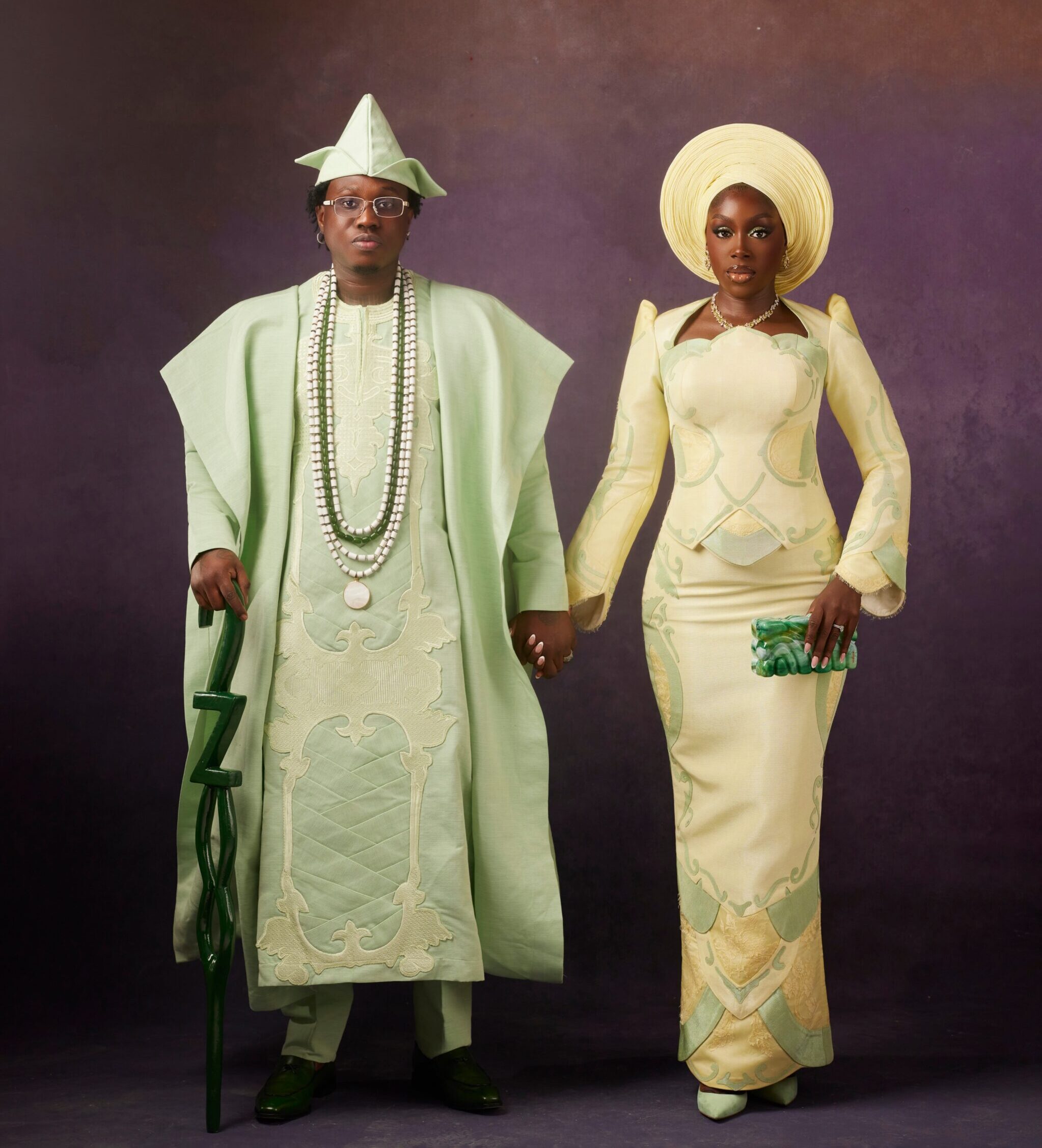Zlatan Ibile in a mint green Mazelle Bridal Agbada holding hands with Davita Omoniyi in a pale lemon-yellow Mazelle Bridal structured top and skirt for their Yoruba traditional wedding.
