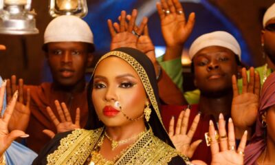 Yemi Alade wearing a black and gold-embroidered abaya with traditional gold jewellery in the Alhaja music video.