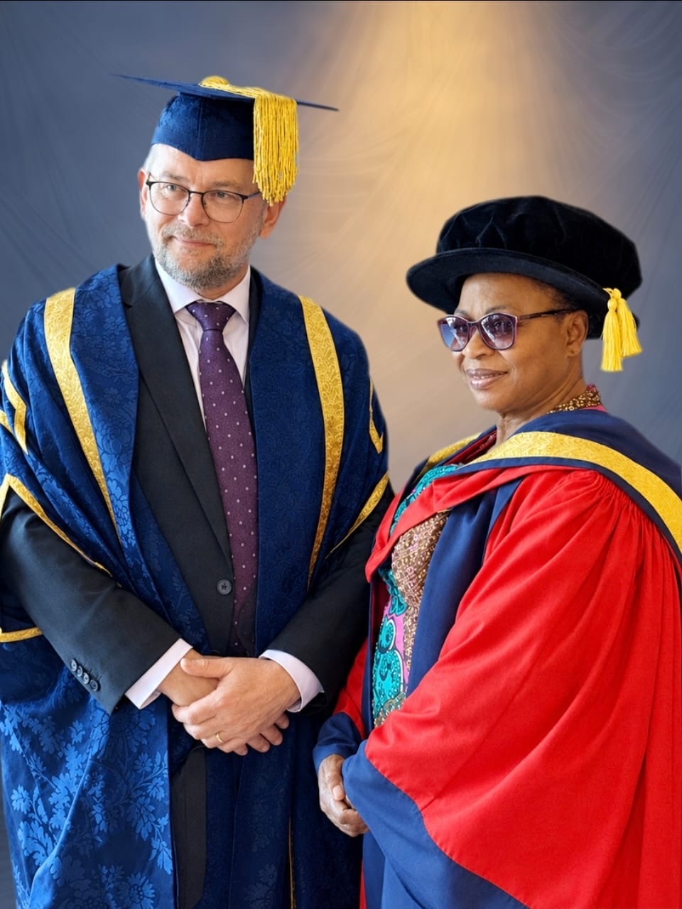 Folorunso Alakija wearing a red academic gown alongside Vice-Chancellor Professor David Cole in ceremonial robes.