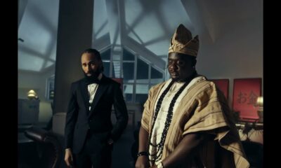 Phyno in a black suit beside Wande Coal in traditional Yoruba Agbada and Fila cap in the Ndewo music video directed by TG Omori.
