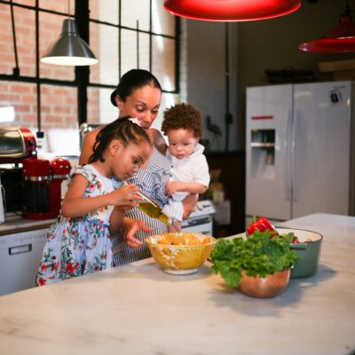 Mother and children preparing food in a bright, cosy kitchen setting. Credit: RDNE Stock Project/Pexels.